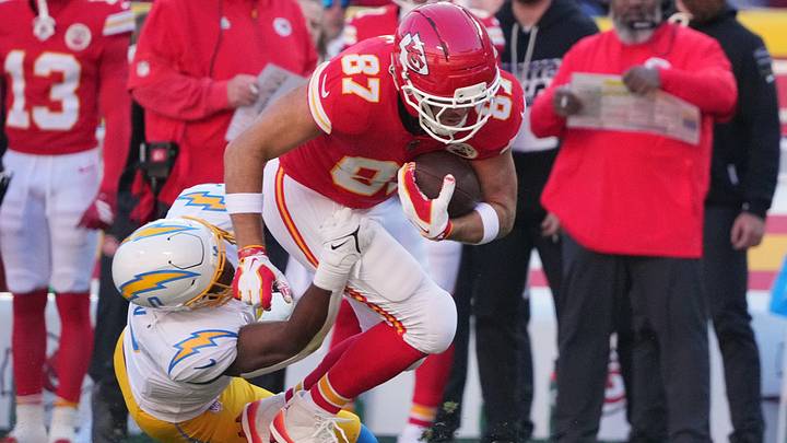 Oct 18, 2026; Kansas City, Missouri, USA;  Kansas City Chiefs tight end Travis Kelce (87) rushes and is tackled by Los Angeles Chargers linebacker Daiyan Henley (0) during the first quarter at GEHA Field at Arrowhead Stadium.  Mandatory Credit: Denny Medley-Imagn Images