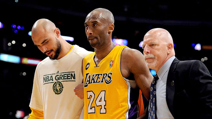 April 12, 2013; Los Angeles, CA, USA; Los Angeles Lakers trainer Gary Vitti and center Robert Sacre (50) help shooting guard Kobe Bryant (24) as leaves the game in the fourth quarter against the Golden State Warriors at the Staples Center. Bryant suffered a torn Achilles tendon. He under went surgery April 13 and is expected to miss six to nine months. Mandatory Credit: Jayne Kamin-Oncea-Imagn Images April 12, 2013; Los Angeles, CA, USA; Los Angeles Lakers trainer Gary Vitti and center Robert Sacre (50) help shooting guard Kobe Bryant (24) as leaves the game in the fourth quarter against the Golden State Warriors at the Staples Center. Bryant suffered a torn Achilles tendon. He under went surgery April 13 and is expected to miss six to nine months. Mandatory Credit: Jayne Kamin-Oncea-Imagn Images