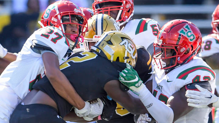 Mississippi Valley defensive back Prince Ijioma (27) and defensive lineman Donovan Parham (42) stop Alabama State Hornets running back Tacaris Bozeman (2) during their game on the ASU campus in Montgomery, Ala., on Saturday October 12, 2024.