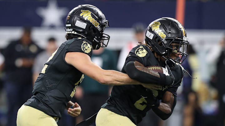 South Oak Cliff's Carter Kopecky (12) hands the ball off to Mikail Trotter (2) during the Class 5A, Division II State Championship game on Friday, Dec. 20, 2024, at AT&T Stadium in Arlington, Texas.
