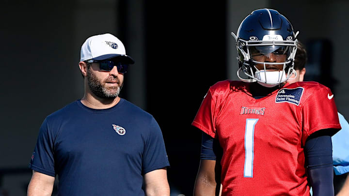Tennessee Titans head coach Brian Callahan talks with quarterback Cam Ward.
