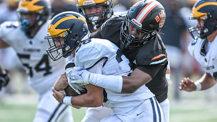 Clarkston running back Griffin Boman drags a Belleville tackler early in the 2024 Michigan high school football season.