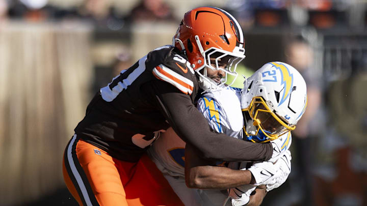 Nov 3, 2024; Cleveland, Ohio, USA; Los Angeles Chargers running back J.K. Dobbins (27) runs the ball as Cleveland Browns linebacker Devin Bush (30) tackles him during the second quarter at Huntington Bank Field. Mandatory Credit: Scott Galvin-Imagn Images