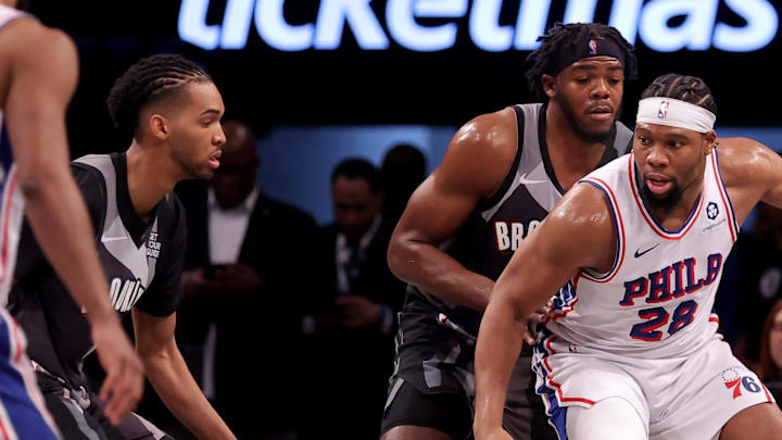 Feb 12, 2025; Brooklyn, New York, USA; Philadelphia 76ers forward Guerschon Yabusele (28) controls the ball against Brooklyn Nets center Day'Ron Sharpe (20) and forward Ziaire Williams (8) during the second quarter at Barclays Center. Mandatory Credit: Brad Penner-Imagn Images