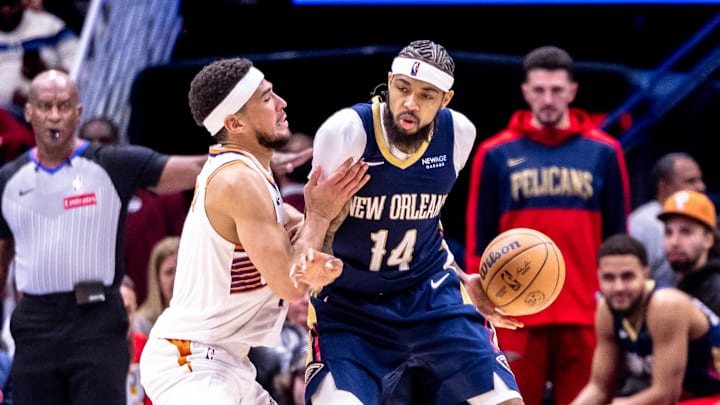Dec 5, 2024; New Orleans, Louisiana, USA;  New Orleans Pelicans forward Brandon Ingram (14) dribbles against Phoenix Suns guard Devin Booker (1) during the second half  at Smoothie King Center. Mandatory Credit: Stephen Lew-Imagn Images