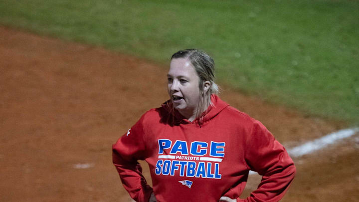 Patriots head coach Lexi Alexander cheers on her team during the Tate vs. Pace softball game at Pace High School on Thursday, March 7, 2024.