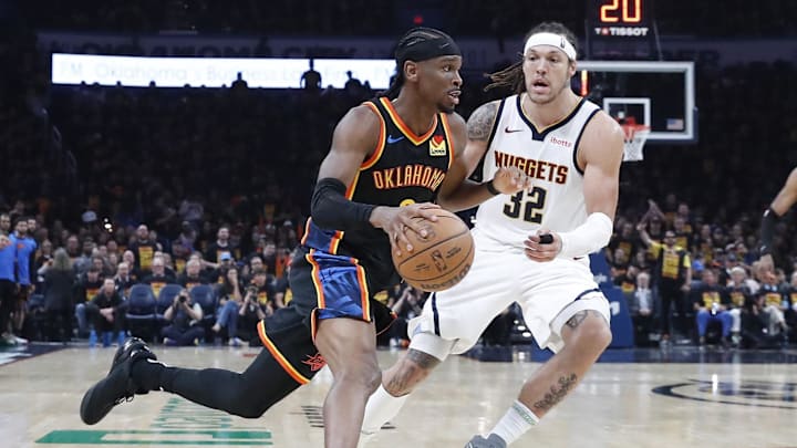 May 5, 2025; Oklahoma City, Oklahoma, USA; Oklahoma City Thunder guard Shai Gilgeous-Alexander (2) drives around Denver Nuggets forward Aaron Gordon (32) during the second half during game one of the second round for the 2025 NBA Playoffs at Paycom Center. Mandatory Credit: Alonzo Adams-Imagn Images