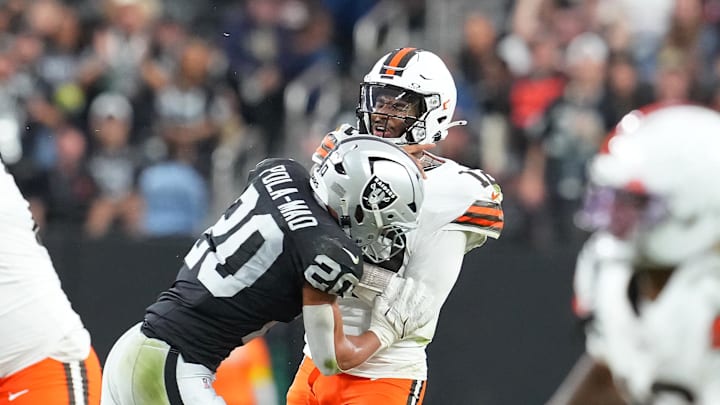 Nov 23, 2025; Paradise, Nevada, USA; Cleveland Browns quarterback Shedeur Sanders (12) is hit by Las Vegas Raiders safety Isaiah Pola-Mao (20) after making a pass attempt during the fourth quarter at Allegiant Stadium. Mandatory Credit: Stephen R. Sylvanie-Imagn Images