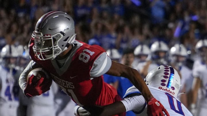 Hamilton Southeastern Royals cornerback Donovan Rhodes (0) attempts to bring down Fishers Tigers (81) during the annual Mudsock Game between rivals Hamilton Southeastern Royals and Fishers Tigers on Friday, Sept. 8, 2023, at Fishers High School in Fishers. Hamilton Southeastern Royals took home the trophy after a 35-34 overtime victory.