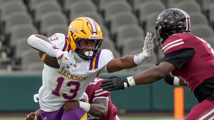 Dec 5, 2025; Birmingham, AL, USA; Jackson's EJ Crowell (13) stiff arms Anniston's Charles Thomas (11) as he runs the ball at Protective Life Stadium in the AHSAA 4A State Championship game.