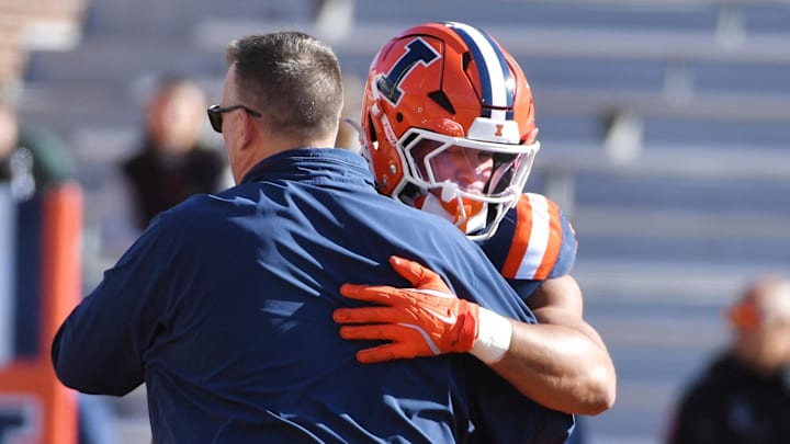 Nov 1, 2025; Champaign, Illinois, USA;  Illinois Fighting Illini head coach Bret Bielema greets player running back Ca'Lil Valentine (5) before an NCAA game against the Rutgers Scarlet Knights at Memorial Stadium. Mandatory Credit: Ron Johnson-Imagn Images