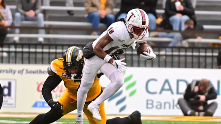 Troy Trojans wide receiver DJ Epps (18) runs the ball while defended by Southern Miss Golden Eagles nose tackle Isaiah Gibson Sr. (7) during a college football game between Southern Miss and Troy at M.M. Roberts Stadium in Hattiesburg, Miss., on Saturday, Nov. 29, 2025. Troy defeated Southern Miss 28-18.