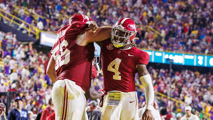 Nov 9, 2024; Baton Rouge, Louisiana, USA;  Alabama Crimson Tide quarterback Jalen Milroe (4) celebrates a touchdown with offensive lineman Geno VanDeMark (56) against the LSU Tigers during the second half at Tiger Stadium. Mandatory Credit: Stephen Lew-Imagn Images