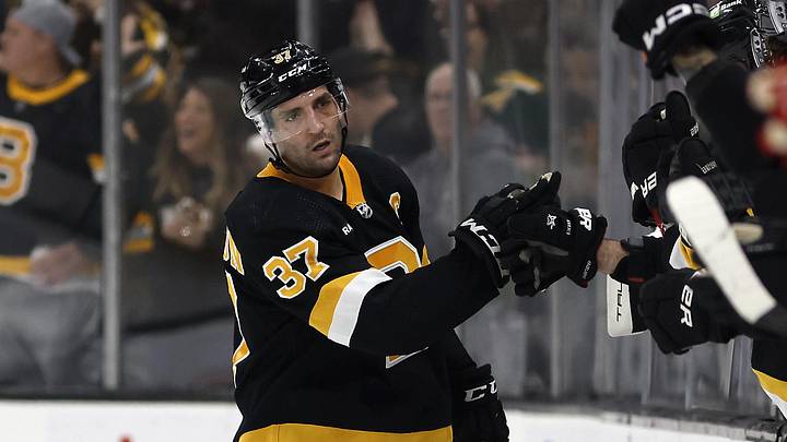 Mar 11, 2023; Boston, Massachusetts, USA; Boston Bruins center Patrice Bergeron (37) is congratulated at the bench after scoring against the Detroit Red Wings during the second period at TD Garden. Mandatory Credit: Winslow Townson-Imagn Images