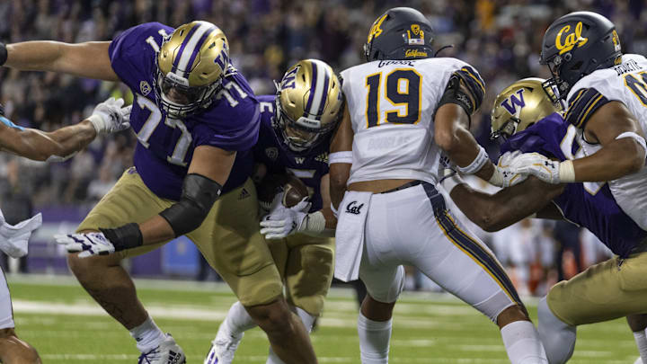 Husky offensive guard Julius Buelow (77) tries to open up a hole against California in 2021.