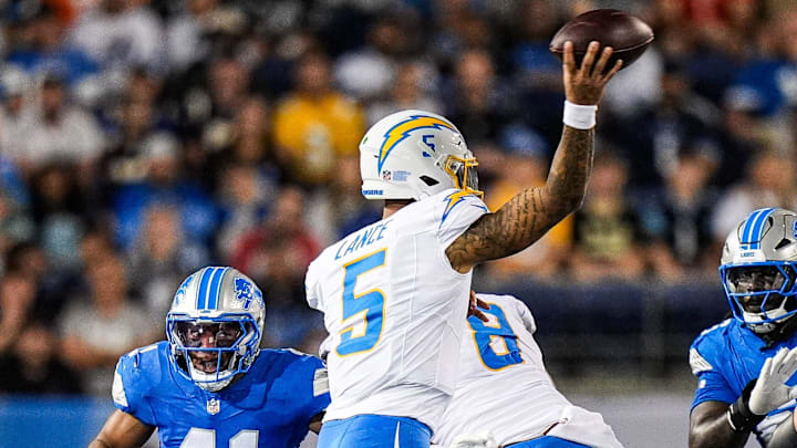 Detroit Lions linebacker Anthony Pittman, left, tries to tackle LA Chargers quarterback Trey Lance.