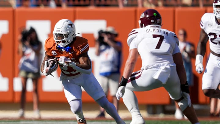 Sep 28, 2024; Austin, Texas, USA;  Texas Longhorns running back Jaydon Blue (23) runs the ball in front of Mississippi State Bulldogs linebacker Stone Blanton (7) in the first half at Darrell K Royal-Texas Memorial Stadium. Mandatory Credit: Daniel Dunn-Imagn Images