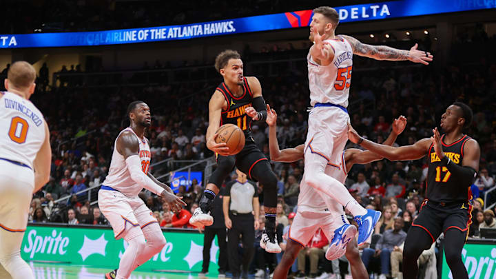 Nov 15, 2023; Atlanta, Georgia, USA; Atlanta Hawks guard Trae Young (11) passes around New York Knicks center Isaiah Hartenstein (55) in the second half at State Farm Arena. Mandatory Credit: Brett Davis-Imagn Images