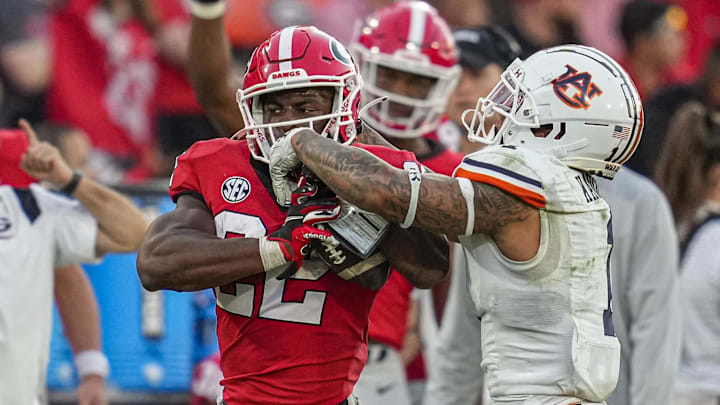 Oct 8, 2022; Athens, Georgia, USA; Georgia Bulldogs running back Branson Robinson (22) tries to break a tackle by Auburn Tigers safety Donovan Kaufman (1) during the second half at Sanford Stadium. Mandatory Credit: Dale Zanine-Imagn Images