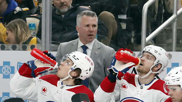 Feb 22, 2024; Pittsburgh, Pennsylvania, USA; Montreal Canadiens head coach Martin St. Louis (top) looks on from the bench against the Pittsburgh Penguins during the second period at PPG Paints Arena. The Penguins won 4-1. Mandatory Credit: Charles LeClaire-Imagn Images