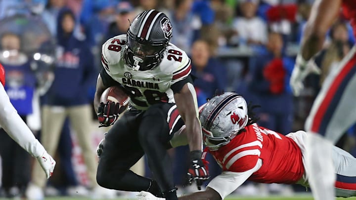 Nov 1, 2025; Oxford, Mississippi, USA; South Carolina Gamecocks running back Matt Fuller (28) runs the ball as Mississippi Rebels linebacker Princewill Umanmielen (1) attempts to make the tackle during the second quarter at Vaught-Hemingway Stadium. Mandatory Credit: Petre Thomas-Imagn Images