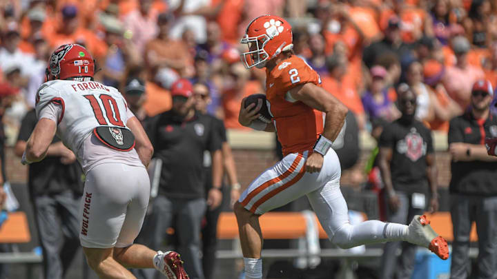 Sep 21, 2024; Clemson, South Carolina, USA; Clemson Tigers quarterback Cade Klubnik (2) runs for a first down against North Carolina State Wolfpack linebacker Caden Fordham (10) during the second quarter at Memorial Stadium.