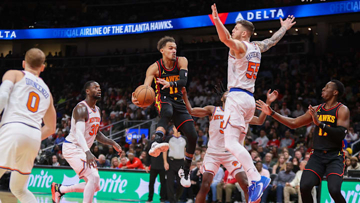 Nov 15, 2023; Atlanta, Georgia, USA; Atlanta Hawks guard Trae Young (11) passes around New York Knicks center Isaiah Hartenstein (55) in the second half at State Farm Arena. Mandatory Credit: Brett Davis-Imagn Images