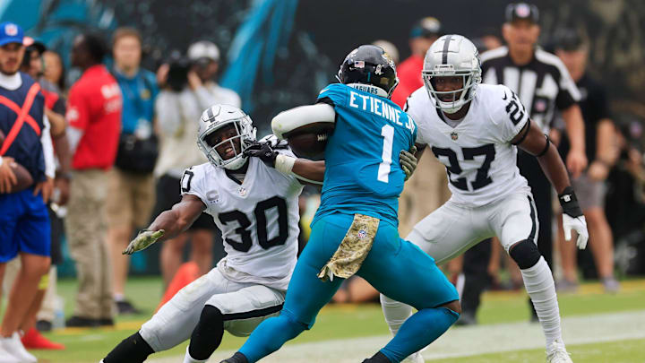 Jacksonville Jaguars running back Travis Etienne Jr. (1) is tackled by Las Vegas Raiders safety Duron Harmon (30) as cornerback Sam Webb (27) looks on during the second quarter of a regular season NFL football matchup Sunday, Nov. 6, 2022 at TIAA Bank Field in Jacksonville. The Jacksonville Jaguars held off the Las Vegas Raiders 27-20. [Corey Perrine/Florida Times-Union]

Jki 110622 Raiders Jags Cp 146