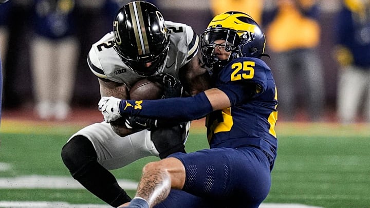 Michigan defensive back Mason Curtis (25) tackles Purdue wide receiver Michael Jackson III (2) during the second half at Michigan Stadium in Ann Arbor on Saturday, November 1, 2025.