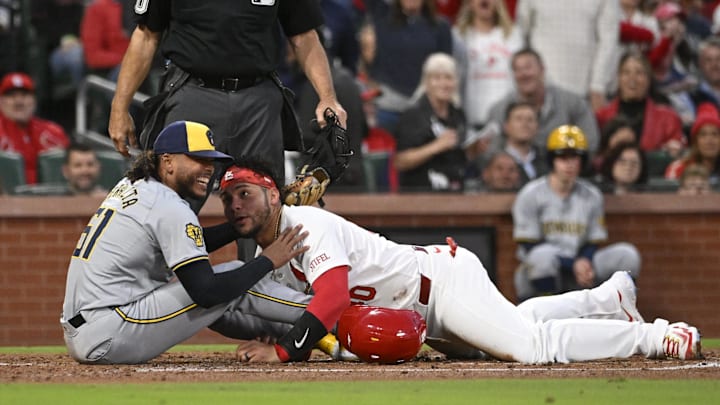 Apr 19, 2024; St. Louis, Missouri, USA; Milwaukee Brewers pitcher Freddy Peralta (51) laughs with St. Louis Cardinals catcher Willson Contreras (40) after tagging Contreras out at home plate in the second inning at Busch Stadium. Mandatory Credit: Joe Puetz-Imagn Images