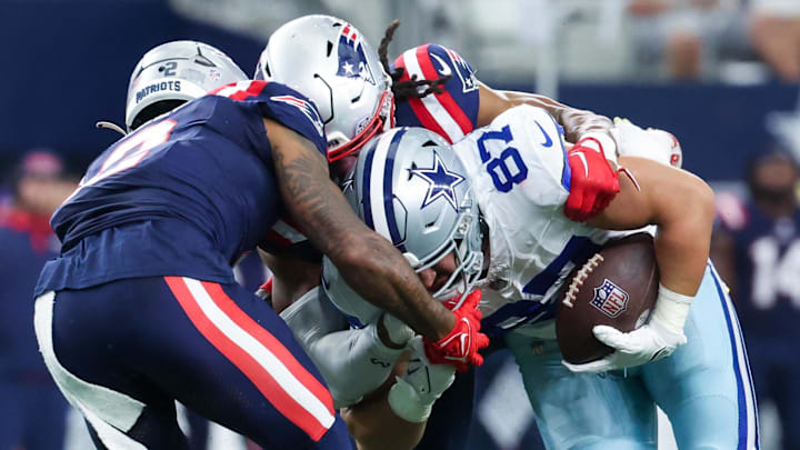 Oct 1, 2023; Arlington, Texas, USA;  Dallas Cowboys tight end Jake Ferguson (87) runs with the ball as New England Patriots cornerback Jalen Mills (2) and New England Patriots safety Kyle Dugger (23) during the first half at AT&T Stadium. Mandatory Credit: Kevin Jairaj-Imagn Images