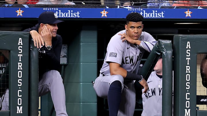 New York Yankees outfielder Juan Soto (right) and manager Aaron Boone (left) watch from the dugout during a March game against the Houston Astros. 