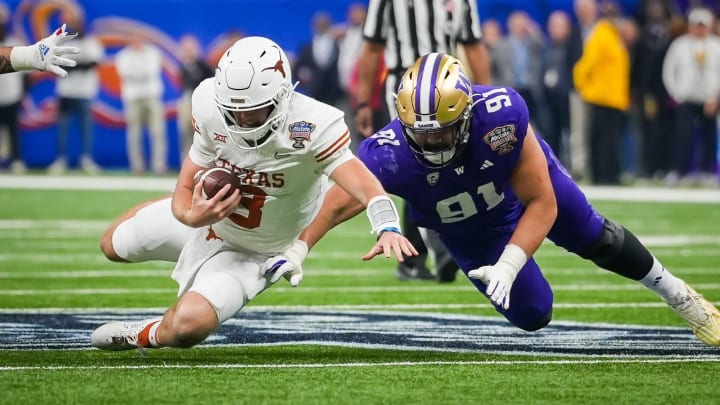 Texas Longhorns quarterback Quinn Ewers (3) and Washington Huskies defensive lineman Tuli Letuligasenoa (91).
