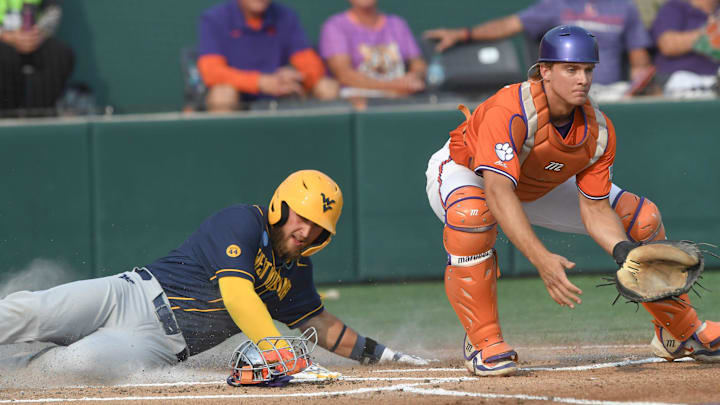 Clemson catcher Jacob Jarrell (9) waits for a throws while West Virginia senior Jace Rinehart (0) scores during the top of the first inning at the NCAA baseball Clemson Regional at Doug Kingsmore Stadium in Clemson, S.C. Saturday, May 31, 2025.