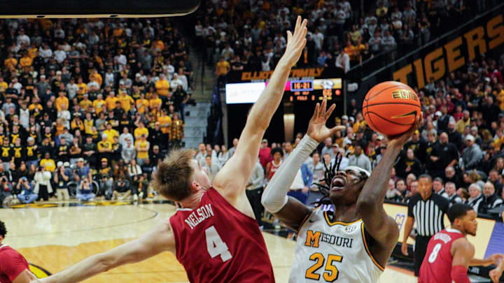 Feb 19, 2025; Columbia, Missouri, USA; Missouri Tigers guard Mark Mitchell (25) shoots as Alabama Crimson Tide forward Grant Nelson (4) defends during the second half at Mizzou Arena. Mandatory Credit: Denny Medley-Imagn Images