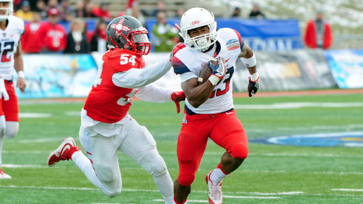 Dec 19, 2015; Albuquerque, NM, USA; Arizona Wildcats running back Jared Baker (23) dodges a tackle by New Mexico Lobos linebacker Donnie White (54) during a 27 yard touchdown run in the second half in the 2015 New Mexico Bowl at University Stadium. Mandatory Credit: Matt Kartozian-Imagn Images