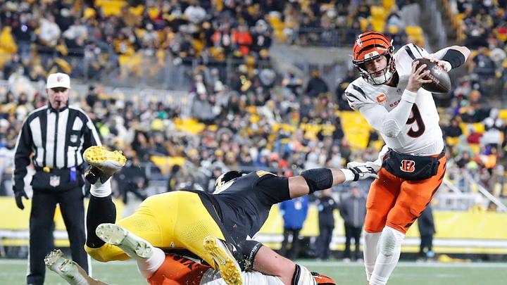 Jan 4, 2025; Pittsburgh, Pennsylvania, USA; Cincinnati Bengals quarterback Joe Burrow (9) avoids a tackle attempt by Pittsburgh Steelers defensive tackle Cameron Heyward (97) as Bengals guard Cody Ford (61) blocks during the third quarter at Acrisure Stadium. Mandatory Credit: Charles LeClaire-Imagn Images Jan 4, 2025; Pittsburgh, Pennsylvania, USA; Cincinnati Bengals quarterback Joe Burrow (9) avoids a tackle attempt by Pittsburgh Steelers defensive tackle Cameron Heyward (97) as Bengals guard Cody Ford (61) blocks during the third quarter at Acrisure Stadium. Mandatory Credit: Charles LeClaire-Imagn Images