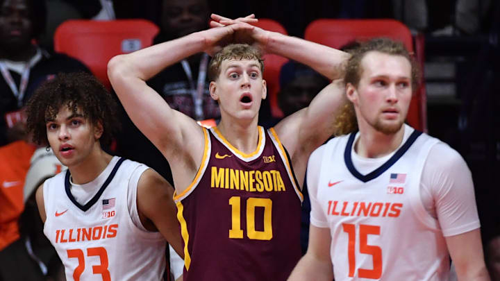 Jan 17, 2026; Champaign, Illinois, USA;  Minnesota Golden Gophers guard Cade Tyson (10) stands between Illinois Fighting Illini guard Keaton Wagler (23) and Jake Davis (15) and reacts after fouling out during the second half at State Farm Center. Mandatory Credit: Ron Johnson-Imagn Images