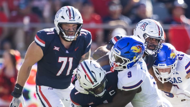 Nov 8, 2025; Tucson, Arizona, USA; Arizona Wildcats quarterback Noah Fifita (1) is sacked by Kansas Jayhawks defensive end Dakyus Brinkley (9) in the first half at Arizona Stadium. Mandatory Credit: Mark J. Rebilas-Imagn Images
