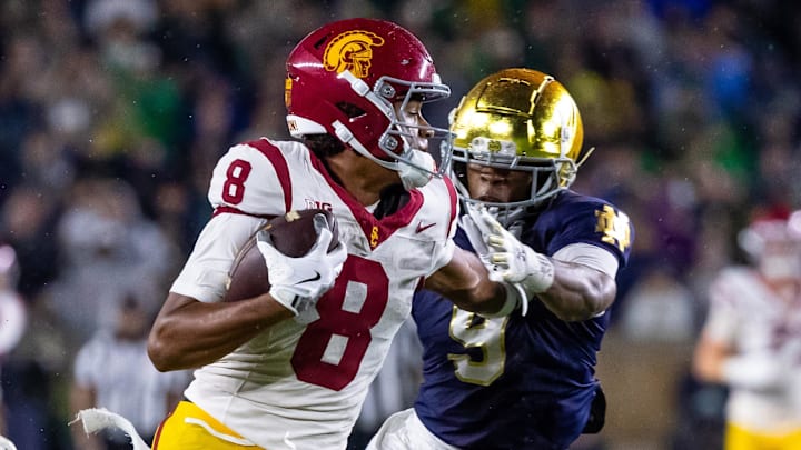 Oct 18, 2025; South Bend, Indiana, USA; Southern California Trojans wide receiver Ja'Kobi Lane (8) breaks a tackle by Notre Dame Fighting Irish safety Tae Johnson (9) during the second half at Notre Dame Stadium. Mandatory Credit: Michael Caterina-Imagn Images