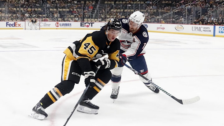Oct 4, 2024; Pittsburgh, Pennsylvania, USA;  Pittsburgh Penguins defenseman Harrison Brunicke (45) skates in on goal against Columbus Blue Jackets center Sean Kuraly (7) during the first period at PPG Paints Arena. Mandatory Credit: Charles LeClaire-Imagn Images