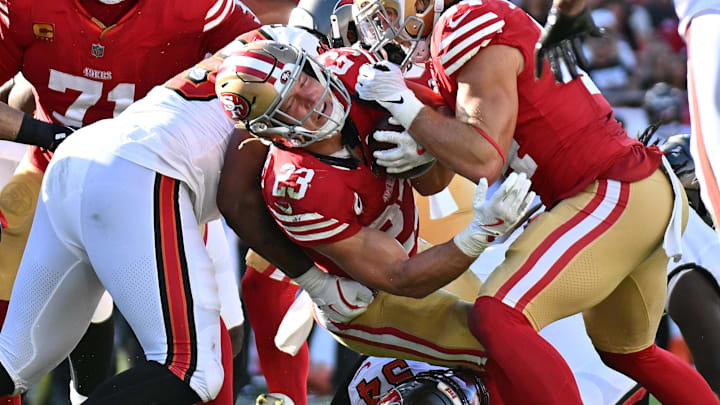 Oct 12, 2025; Tampa, Florida, USA; San Francisco 49ers running back Christian McCaffrey (23) is tackled by Tampa Bay Buccaneers outside linebacker Lavonte David (54) and defensive end Elijah Roberts (95) during the second quarter at Raymond James Stadium. Mandatory Credit: Jonathan Dyer-Imagn Images