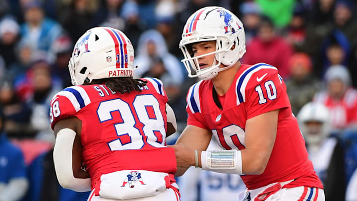 Dec 1, 2024; Foxborough, Massachusetts, USA;  New England Patriots quarterback Drake Maye (10) hands the ball off to running back Rhamondre Stevenson (38) during the first half against the Indianapolis Colts at Gillette Stadium. Mandatory Credit: Bob DeChiara-Imagn Images