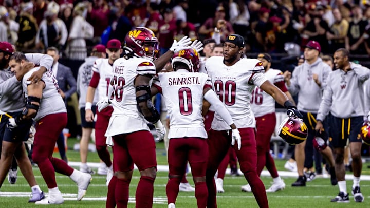 Dec 15, 2024; New Orleans, Louisiana, USA;  Washington Commanders cornerback Mike Sainristil (0) and defensive end Javontae Jean-Baptiste (90) celebrate a New Orleans Saints failed attempt on a two point conversion as time expires at Caesars Superdome. Mandatory Credit: Stephen Lew-Imagn Images