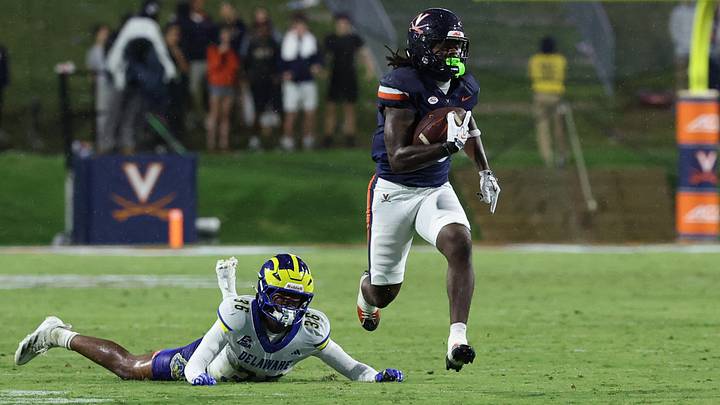 Sep 26, 2026; Charlottesville, Virginia, USA; Virginia Cavaliers wide receiver Josiah Abdullah (13) runs with the ball en route to a touchdown as Delaware Blue Hens defensive back Nasir Eatmon (36) looks on during the second half at Scott Stadium. Mandatory Credit: Geoff Burke-Imagn Images Sep 26, 2026; Charlottesville, Virginia, USA; Virginia Cavaliers wide receiver Josiah Abdullah (13) runs with the ball en route to a touchdown as Delaware Blue Hens defensive back Nasir Eatmon (36) looks on during the second half at Scott Stadium. Mandatory Credit: Geoff Burke-Imagn Images