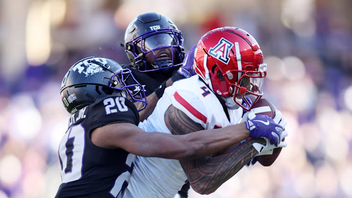 Nov 23, 2024; Fort Worth, Texas, USA; Arizona Wildcats wide receiver Tetairoa McMillan (4) catches a pass against TCU Horned Frogs cornerback Jevon McIver Jr. (20) and safety Jamel Johnson (2) in the second quarter at Amon G. Carter Stadium. 