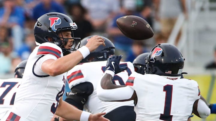 Penn quarterback Aidan Sayin (left) and running back Malachi Hosley have trouble with a snap in the first quarter against Delaware at Delaware Stadium, Saturday, Sept. 21, 2024.