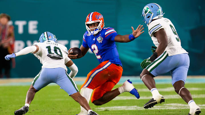 Florida Gators quarterback DJ Lagway (2) eludes Tulane Green Wave defensive back Lu Tillery (10) and Tulane Green Wave linebacker Terrell Allen (9) during the second half at Raymond James Stadium in Tampa, FL on Friday, December 20, 2024 in the 2024 Union Home Mortgage Gasparilla Bowl. The Gators defeated Tulane 33-8. [Doug Engle/Gainesville Sun]