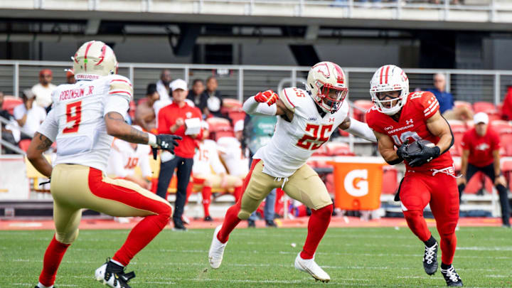 Mar 30, 2025; Washington, D.C., USA; DC Defenders wide receiver Chris Rowland (12) runs the ball as Birmingham Stallions cornerback Rachad Wildgoose defends in the second half at Audi Field.