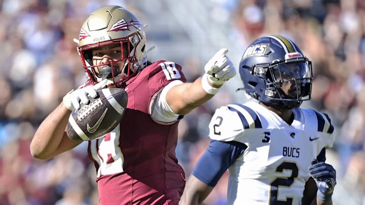 Nov 23, 2024; Tallahassee, Florida, USA; Florida State Seminoles tight end Landen Thomas (18) celebrates a first down grab as Charleston Southern Buccaneers safety Davion Williams (2) looks on during the second half of the game at Doak S. Campbell Stadium. Mandatory Credit: Melina Myers-Imagn Images Nov 23, 2024; Tallahassee, Florida, USA; Florida State Seminoles tight end Landen Thomas (18) celebrates a first down grab as Charleston Southern Buccaneers safety Davion Williams (2) looks on during the second half of the game at Doak S. Campbell Stadium. Mandatory Credit: Melina Myers-Imagn Images